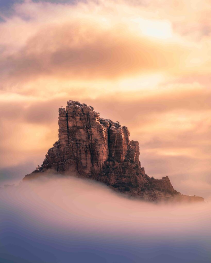 Castle Rock in the soft sunrise light with fog below